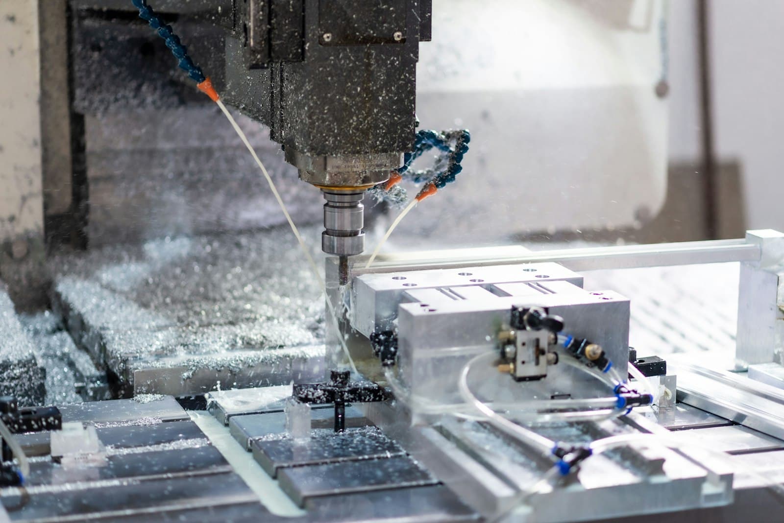 A CNC mill cutting an aluminium part as coolant sprays